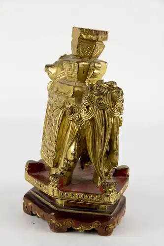 Figur, China, 19./20. Jh., Holz geschnitzt, Fo-Hund mit Vase auf Rücken, auf Sockel stehend, mit Rotlack überzogen und vergoldet. Schwundriss im Sockel, Gebrauchsspuren, schöne Arbeit. H: 20 cm