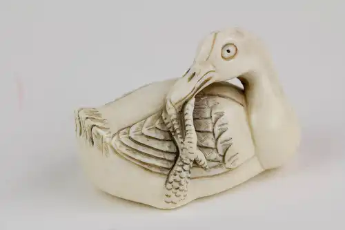 Netsuke, Japan, um 1900, Bein, Ente, schwarz abgesetzt, signiert, Gebrauchsspuren, L: 5 cm.