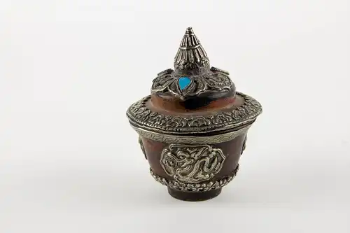 Teeschale, mit Deckel und Ständer, Tibet, 20. Jh., gedrechselte Holzkörper, reichlich mit Weißmetall und Türkisen verziert, Gebrauchsspuren. 

Teapot with cover, Tibet, 20th century, wood, decorated with metal and Turkey stone.