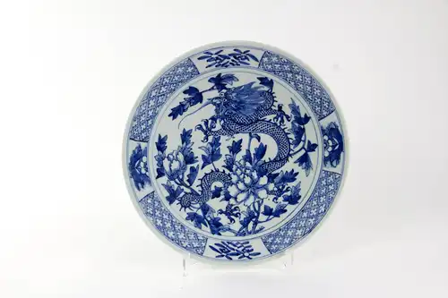 Großer Teller, China, Ende 19. Jh., Porzellan, Blaumalerei, Spiegel mit Drachen und Chrysanthemen verziert, die Fahne mit Ornamenten und Blumen bemalt, kleiner Chip, sonst unbeschädigt, Gebrauchsspuren, D: 30 cm. Plate, end of 19th century, painted...