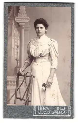 Fotografie Herm. Schulze, Bischofswerda, Portrait junge Dame im hübschen Kleid mit Blume