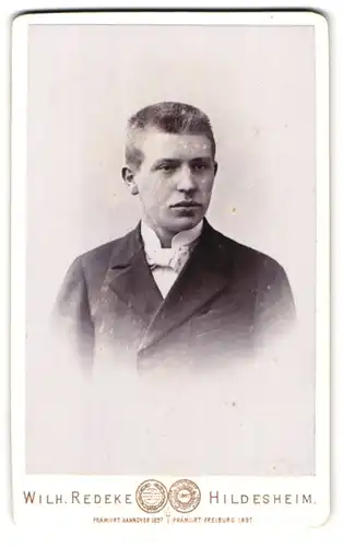 Fotografie Wilh. Redeke, Hildesheim, Kreuzstrasse 22, Portrait Bursche im Jacket mit weisser Fliege