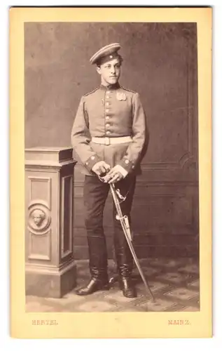 Fotografie Atelier Hertel, Mainz, Ballplatz 4, Einjährig Freiwilliger in Uniform mit Ordenspange und Säbel