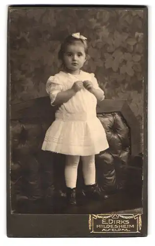 Fotografie E. Dirks, Hildesheim, Zingel 29, Kleines Mädchen im weissen Kleid mit Schleife im Haar