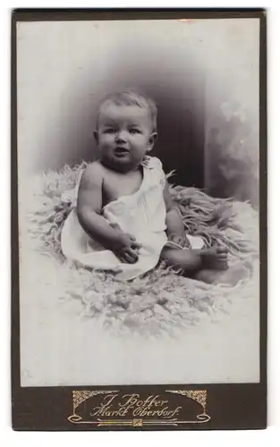 Fotografie J. Hotter, Markt Oberdorf, Portrait süsses Kleinkind im weissen Hemd mit nackigen Füssen