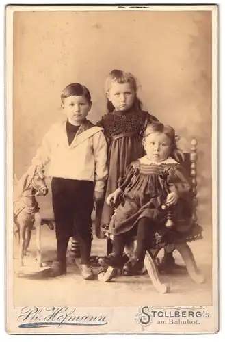 Fotografie Ph. Hofmann, Stollberg i. S., am Bahnhof, Geschwister in eleganter Kleidung mit Schaukelpferd