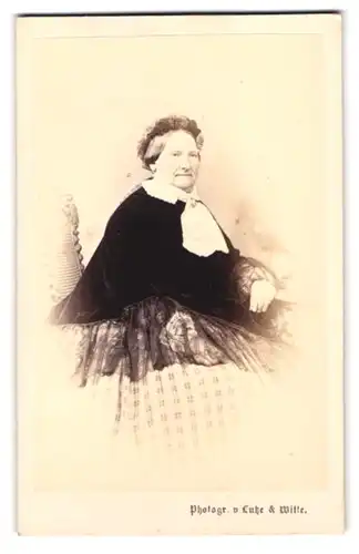 Fotografie Lutze & Witte, Berlin, Neue Friedrichstrasse 50, Portrait alte Frau im karierten Kleid mit schwarzer Jacke