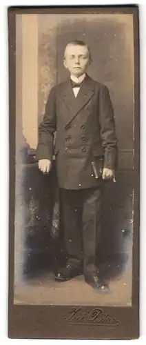 Fotografie Jul. Dürr, Bischofswerda, Portrait junger Knabe im Anzug mit Fliege und einem Buch in der Hand