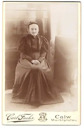 Fotografie Carl Fuchs, Calw, Marktplatz, Portrait alte Frau in langem, schwarzem Kleid