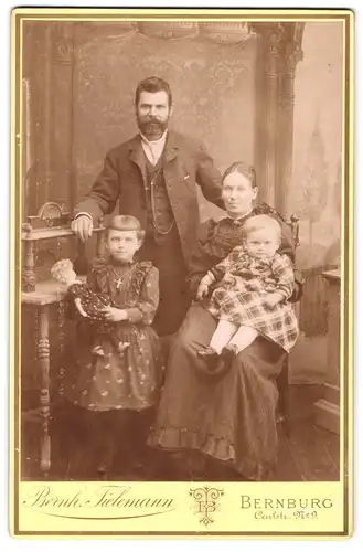 Fotografie Bernh. Tielemann, Bernburg, Carlstrasse 9, Mädchen mit Puppe und Familie