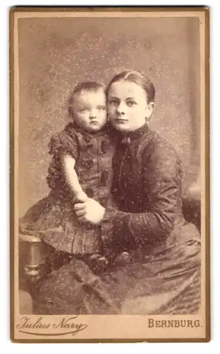 Fotografie Julius Nary, Bernburg, Carlsplatz 29, Portrait bürgerliche Dame mit Kleidnkind im Arm