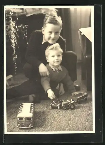 Foto-AK Brüder am Weihnachtsbaum mit ihrem Spielzeug, Panzer, Bus und Traktor