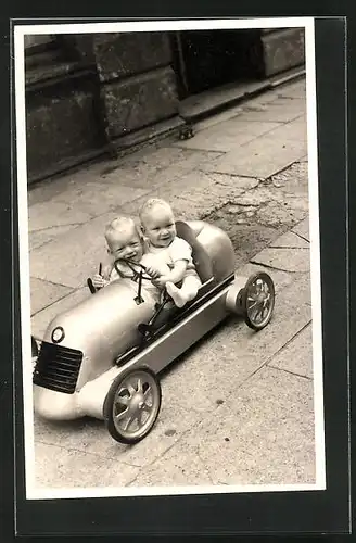 AK Kleinkinder sitzen in einem Tretauto der Marke BMW