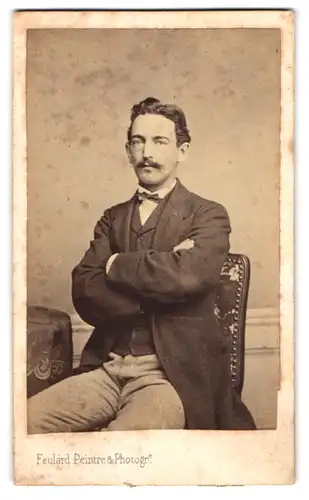 Fotografie A. Feulard, Havre, Portrait Herr im Anzug mit Fliege posiert mit verschrenkten Armen, Moustache, 1867