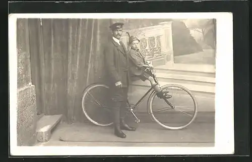 Foto-AK Vater mit Sohn und Fahrrad vor einer Studiokulisse