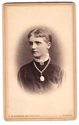 Fotografie C. Michaelsen, Wismar, Junge elegante Frau in schwarzer Kleidung und Broschenkette