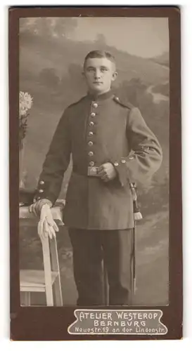 Fotografie Atelier Westerop, Bernburg, Neuestrasse 19, Kindlich aussehender Soldat in Uniform mit Portepee am Bajonett