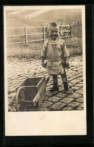 AK Junge im Garten mit einer kleinen Schubkarre, Spielzeug