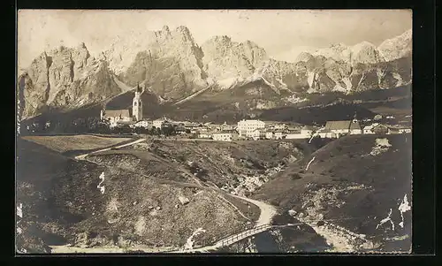 AK Cortina d`Ampezzo, Ortsansicht aus der Vogelschau mit Dolomitenstrasse und Bergpanorama