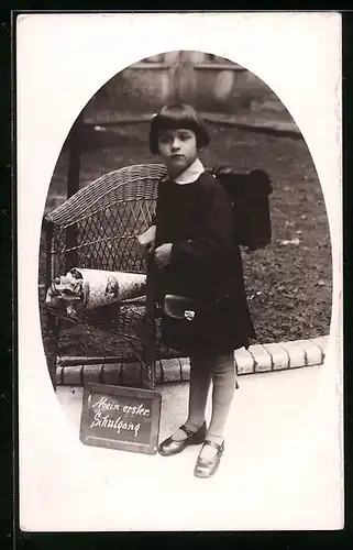 Foto-AK Mädchen mit Schulranzen neben Rattan-Stuhl und Zuckertüte zum Schulanfang