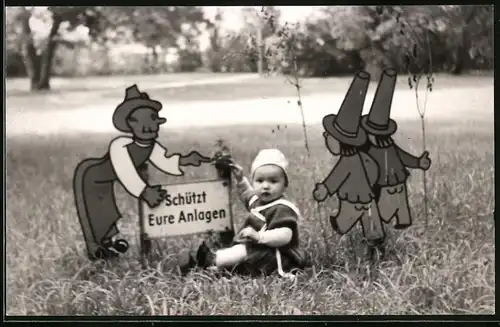 Fotografie niedliches Mädchen zwischen Figuren-Schildern auf einer Grünanlage