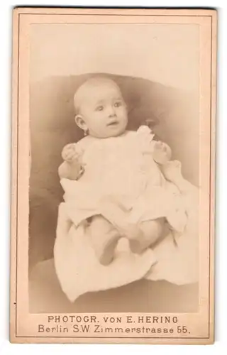 Fotografie E. Hering, Berlin, Zimmerstrasse 55, Kleines Baby mit weisser Kleidung und Ohrring