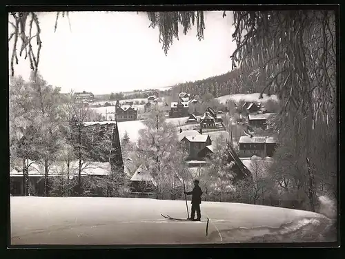 Fotografie Brück & Sohn Meissen, Ansicht Bärenfels / Erzg., Skifahrer schaut auf den verschneiten Ort im Winter