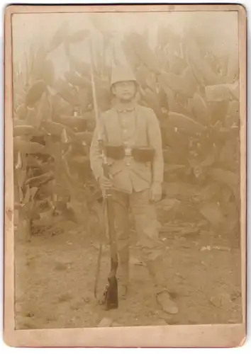 Fotografie Fotograf unbekannt, Deutsch-Südwestafrika Schutztruppe, DSWA - Soldat H. Klein in Tropenuniform mit Gewehr