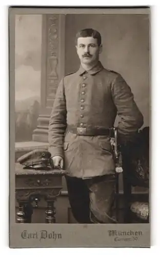 Fotografie Carl Dohn, München, Caristrasse, Soldat in Feldgrau mit Schirmmütze und Säbel