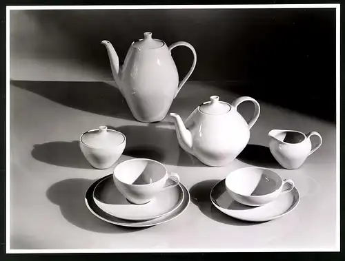 Fotografie Willi Moegle, Stuttgart, schön drapiertes Porzellanservice mit Teekanne, Kaffekanne und Tassen, Lichtspiel