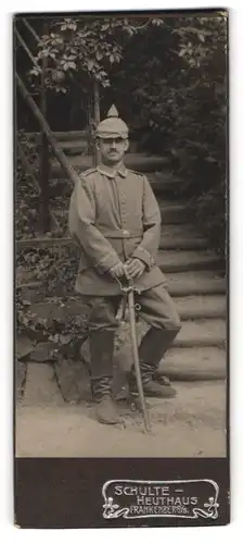 Fotografie Schulte-Heuthaus, Frankenberg i.S., Uffz. in Feldgrau mit Tarnbezug-Pickelhaube und Säbel