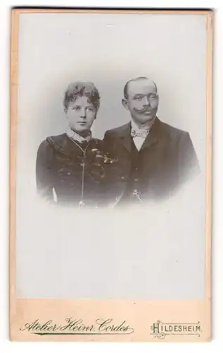 Fotografie Atelier Heinr. Cordes, Hildesheim, Dame mit Stirnlocken und Herr mit Halbglatze und Fliege