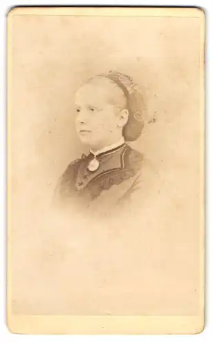 Fotografie I. M. Pfromer, Offenburg, Junge Dame im Kleid mit gebundenem Haar im Halbprofil