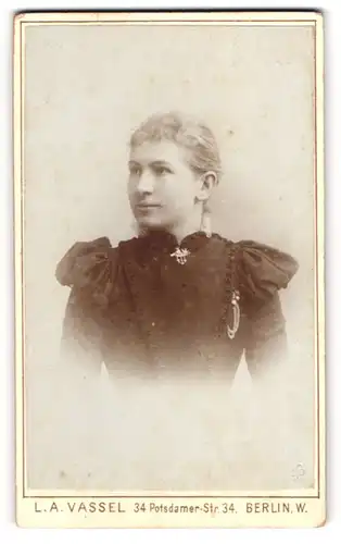 Fotografie L. A. Vassel, Berlin, Potsdamer-Str. 34 Eingang Lützow-Str. 91 a, Junge Dame im Kleid mit Kragenbrosche