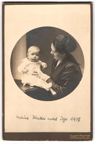 Fotografie Albert Pfeiffer, Ulm, König Wilhelmstrasse 1, Dame mit Duttfrisur hält ein Baby auf einem Tisch