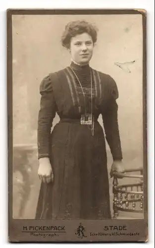 Fotografie H. Pickenpack, Stade, Ecke Höker- und kl. Schmiedestrasse, Junge Dame im modischen Kleid