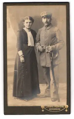 Fotografie Ludwig Mertens, Rendsburg, Am Gymnasium, Soldat mit Säbel in Uniform nebst Gattin