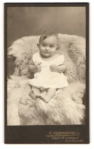 Fotografie R. Rosenkranz, Mügeln, Königstrasse 32, Baby im Kleidchen auf einem Fell sitzend