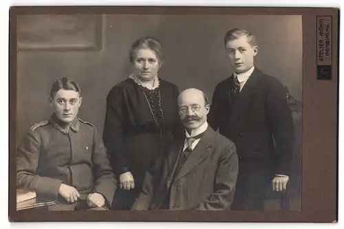 Fotografie Atelier Mohn, Nienburg a. W., Junger Unteroffizier in Uniform mit Bruder und Eltern