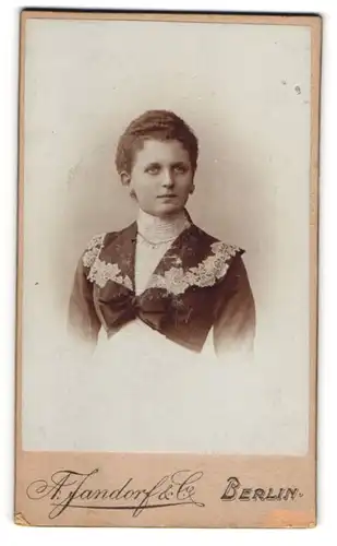 Fotografie A. Jandorf & Co, Berlin, Spittelmarkt 16, Junge Dame in weissem Kleid mit schwarzer Jacke und breiter Schleife