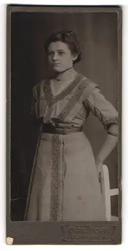 Fotografie Max Hopf, Elsterberg i. / V., Frau mit zurückgesteckten Haaren trägt ein besticktes Kleid