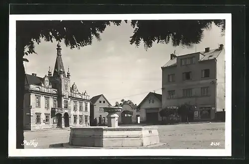 AK Pecky, Marktplatz mit Brunnen und Geschäft