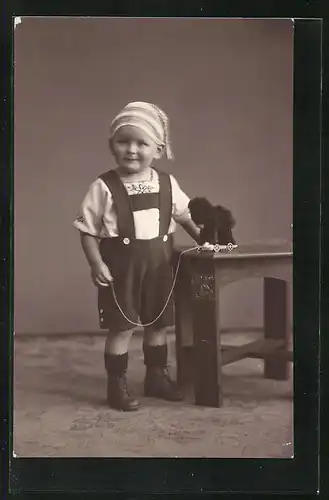 AK Kind in Latzhose mit weissem Tshirt mit Spielzeughund