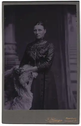 Fotografie F. Flarup, Flensburg, Grossestrasse 75, Portrait bürgerliche Dame mit Blume an Fell gelehnt