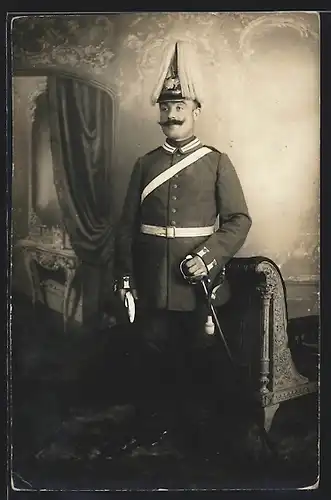 Foto-AK Soldat in Garde Uniform Feldgrau mit Garde Pickelhaube Rosshaarbusch, Säbel mit Portepee