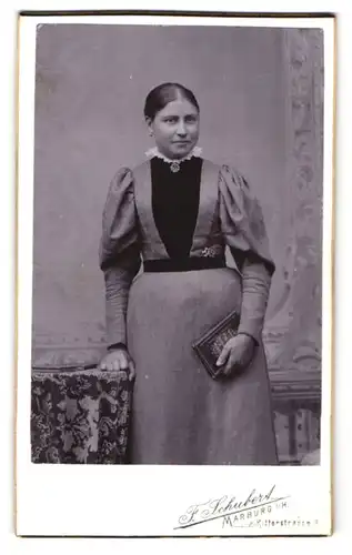 Fotografie F. Schubert, Marburg, Ritterstrasse 4, Feine Dame Dame mit Buch lehnt an Tisch