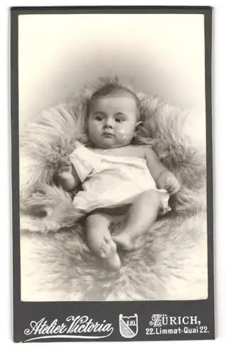 Fotografie Atelier Wertheim, Zürich, Limmat-Quai 22, Baby auf einem Pelz in ein weisses Gewand gekleidet