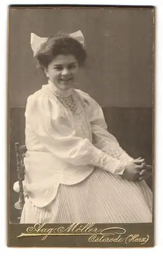 Fotografie Aug. Möller, Osterode (Harz), Mädchen mit dickem Haar mit weisser Schleife, im weissen Kleid mit Puffärmeln