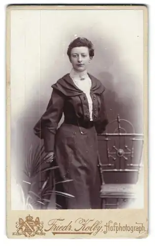 Fotografie Friedr. Kolby, Zwickau i. S., Äuss. Plauensche Str., Junge Dame mit leichtem Lächeln im eleganten Kleid