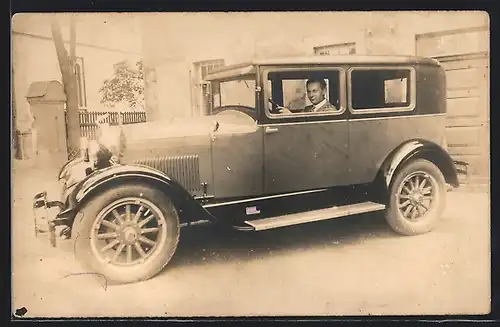 Foto-AK Auto Essex (1928), Junegr Mann am Steuer seines Wagens vor einer Garage